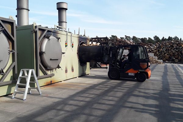 Chargement d’un lot de bûches dans le four à carbonisation
