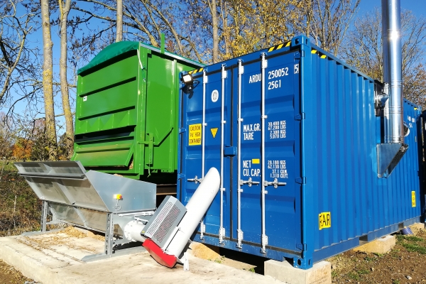 Vue arrière de la chaufferie avec le container « chaudière (bleu) et le container-silo amovible (vert)